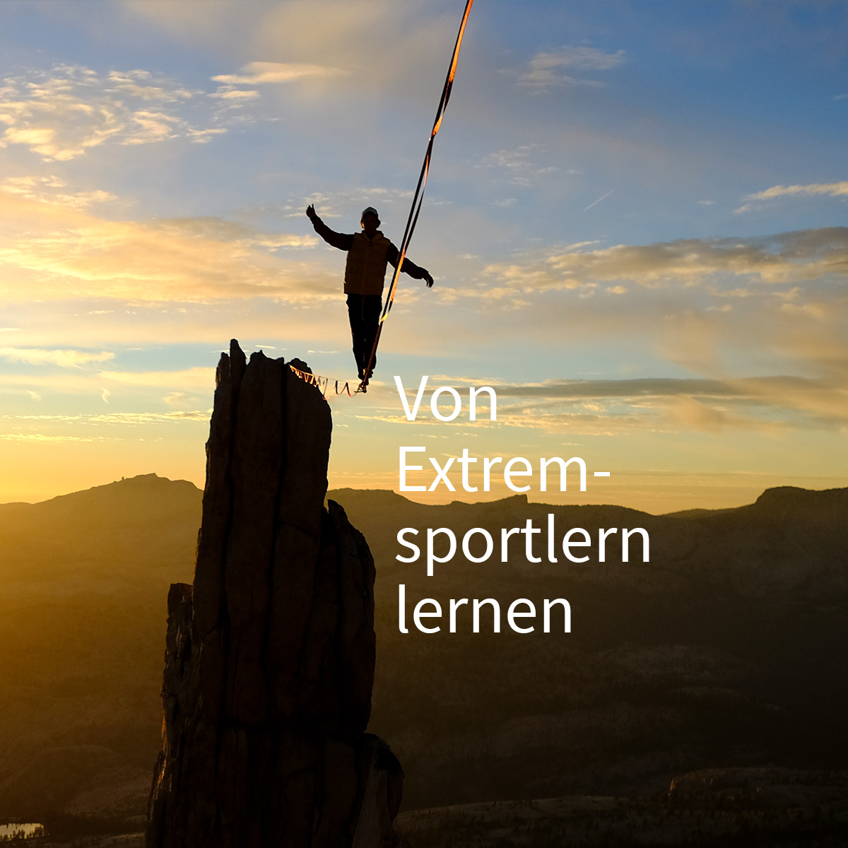 Ein Mann steht auf einer Slackline, die zwischen zwei Felsen gespannt ist